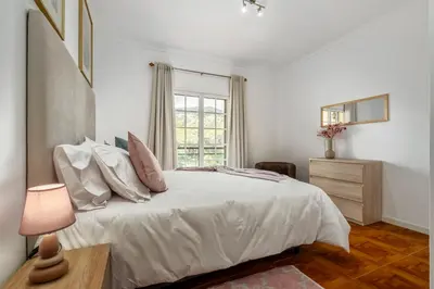 a white bedroom with a bed and a window at Por Do Sol in Calheta