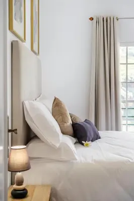 a bedroom with a bed with pillows and a window at Por Do Sol in Calheta