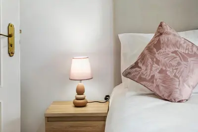 a lamp on a night stand next to a bed at Por Do Sol in Calheta