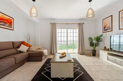 a living room with a couch and a tv at Por Do Sol in Calheta