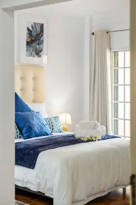 a bedroom with a large bed with blue pillows at Por Do Sol in Calheta