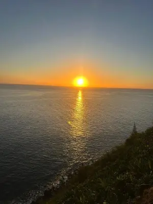 a sunset over the ocean with the sun setting at Paradise House in Ponta do Sol