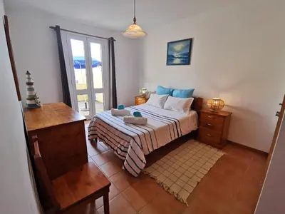 a bedroom with a bed and a dresser and a window at Sea & Sand Guest House in Porto Santo