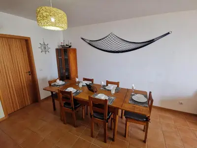a dining room with a wooden table and chairs at Sea & Sand Guest House in Porto Santo