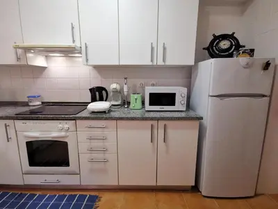a kitchen with a white refrigerator and a microwave at Sea & Sand Guest House in Porto Santo
