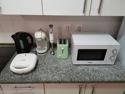 a kitchen counter with a microwave and appliances on it at Sea & Sand Guest House in Porto Santo
