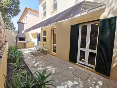 a patio with a table and chairs in front of a house at Sea & Sand Guest House in Porto Santo