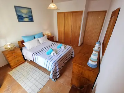 a bedroom with a bed with two stuffed animals on it at Sea & Sand Guest House in Porto Santo