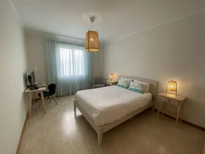 a bedroom with a bed and a desk with a computer at Villas Dragoeiro in Porto Santo
