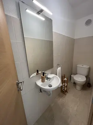 a bathroom with a sink and a mirror and a toilet at Villas Dragoeiro in Porto Santo