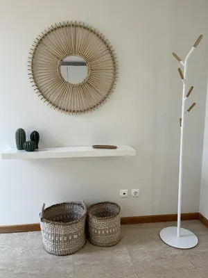 a mirror on a white wall with two baskets at Villas Dragoeiro in Porto Santo