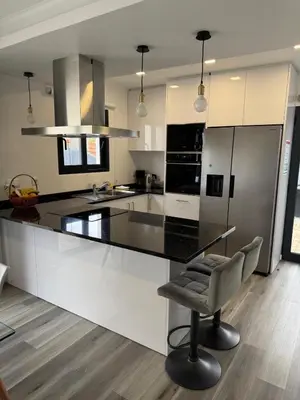 a kitchen with a black and white counter top at Casa do Farol Guest House in São Jorge