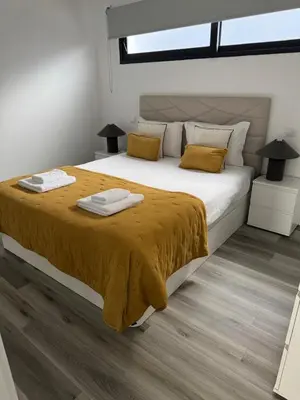 a bedroom with a large white bed with yellow pillows at Casa do Farol Guest House in São Jorge