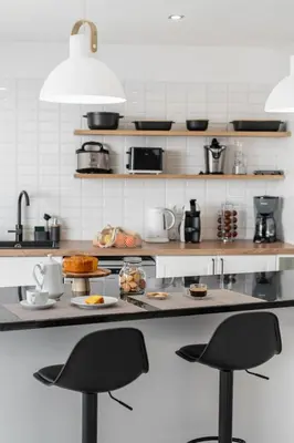 a kitchen with two black bar stools and a counter at With pool and sea view - Vila da Ribeira da Vaca in Calheta