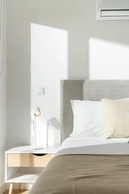 a white bedroom with a bed and a nightstand at With pool and sea view - Vila da Ribeira da Vaca in Calheta