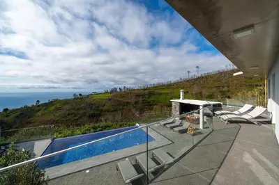 a house with a swimming pool on top of a hill at With pool and sea view - Vila da Ribeira da Vaca in Calheta