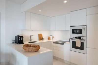 a kitchen with white cabinets and a basket on a counter at With pool and sea view - Acqua Residence III in Funchal