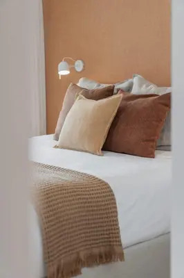 a bed with brown and white pillows on it at With pool and sea view - Acqua Residence III in Funchal