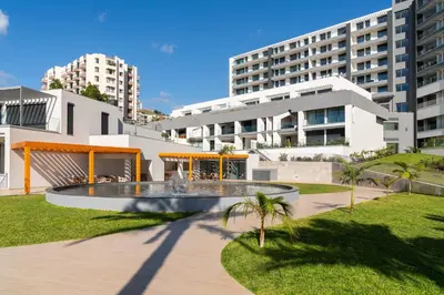 a building with a fountain in the middle of a park at With pool and sea view - Acqua Residence III in Funchal