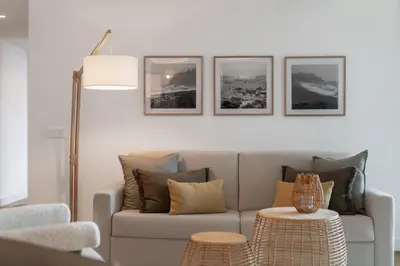 a living room with a couch and three pictures on the wall at With pool and sea view - Acqua Residence III in Funchal