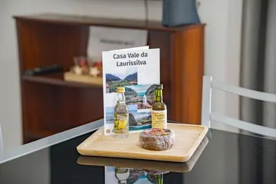 a table with two bottles of wine and a book at Casa Vale da Laurissilva in São Vicente