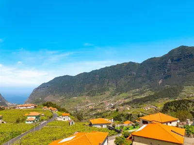 a view of a village with mountains in the background at Casa Vale da Laurissilva in São Vicente
