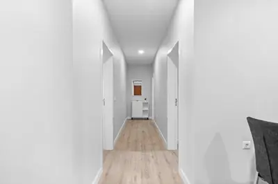 an empty hallway with white walls and wood floors at River Side in Senhora do Rosário