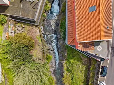 an overhead view of a waterfall next to a building at River Side in Senhora do Rosário