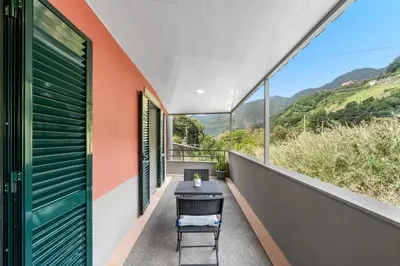 a small table on the balcony of a house at River Side in Senhora do Rosário