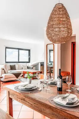 a living room with a table with wine glasses at NEW! Nature Paradise with Ocean View & Hot Tubs in Fajã da Ovelha