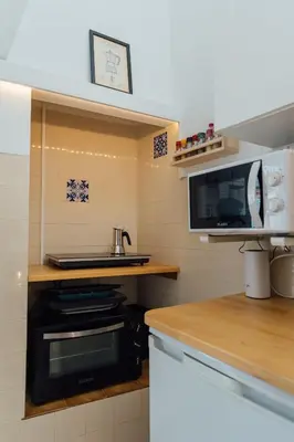 a kitchen with a stove and a microwave at Cozy Old Town Apartment with Sunny Terrace in Vila do Bispo