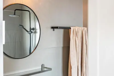 a bathroom with a mirror and a towel at Cozy Old Town Apartment with Sunny Terrace in Vila do Bispo