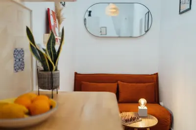 a bowl of oranges on a table with a couch at Cozy Old Town Apartment with Sunny Terrace in Vila do Bispo