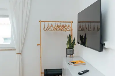 a white room with a desk and a mirror at Cozy Old Town Apartment with Sunny Terrace in Vila do Bispo