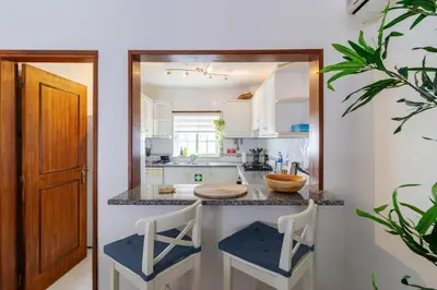 a kitchen with a counter with two stools in front of it at Casa Maisie Apartment in Burgau