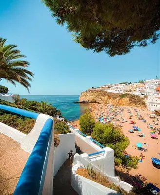 a beach with a bunch of people and the ocean at Casa Maisie Apartment in Burgau