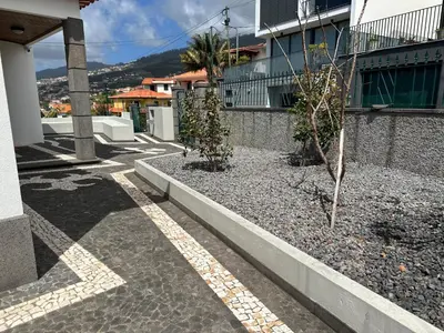 a kitchen with white cabinets and a table with a bowl of fruit at Casa Mollivia - Breath taking views over Funchal in Funchal