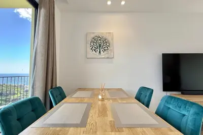 a dining room with a table and a flat screen tv at Anna-Marie House in Ponta do Sol