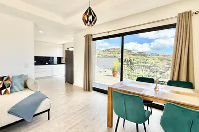 a living room with a dining room table and a large window at Anna-Marie House in Ponta do Sol