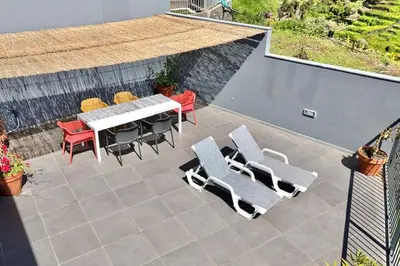 a patio with a table and chairs on a patio at Anna-Marie House in Ponta do Sol