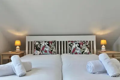 a bedroom with a white bed with two pillows at Anna-Marie House in Ponta do Sol