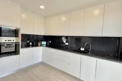 a white kitchen with white cabinets and a sink at Anna-Marie House in Ponta do Sol