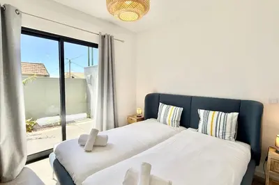 a bedroom with two beds and a large window at Anna-Marie House in Ponta do Sol