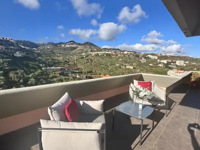 a balcony with a couch and a table with a view at Aylevarroo Penthouse in Caniço
