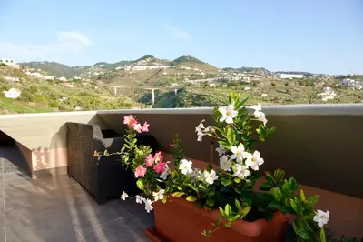 a balcony with flowers and a view of mountains at Aylevarroo Penthouse in Caniço