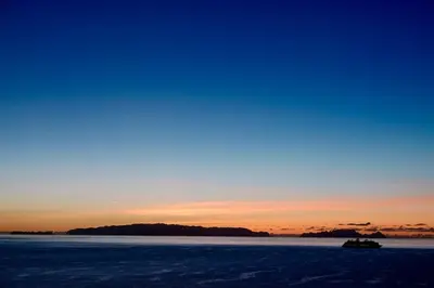 a boat in a body of water at sunset at Aylevarroo Penthouse in Caniço