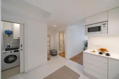 a kitchen with white cabinets and a washer and dryer at With pool in Funchal - Acqua Residence V in Funchal