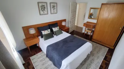 a bedroom with a large bed and a desk at Comboio Funchal in Funchal
