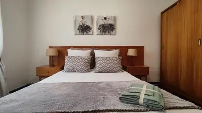 a bedroom with a bed and two pictures on the wall at Comboio Funchal in Funchal