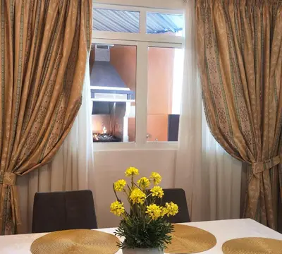 a table with a vase of yellow flowers on it at Comboio Funchal in Funchal